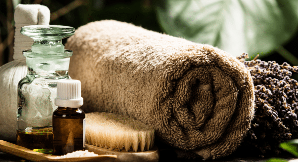 Dyfuzor zapachowy w spa w tle ręcznik olejki i zielone liście